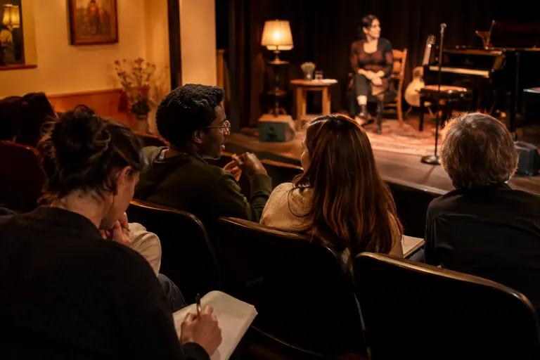 Mixed ensemble rehearsing on a small stage with varied instruments
